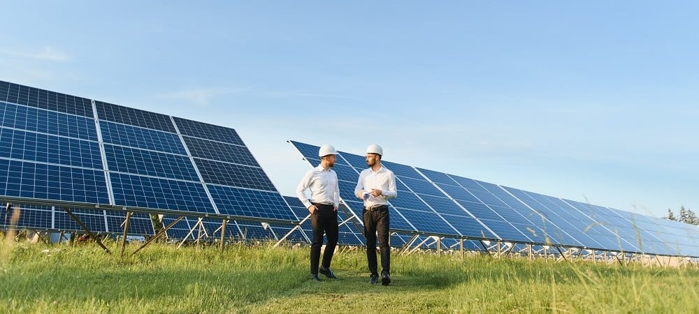 solar panel with two engineers walk to check the operation of the system, Alternative energy to conserve the world's energy, Photovoltaic module idea for clean energy production.